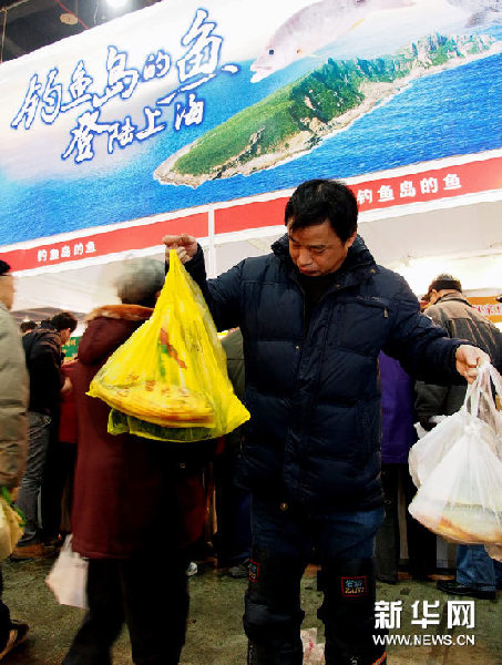 1月26日，一名顾客拿着从钓鱼岛鲜鱼摊位上买到的深海鱼。