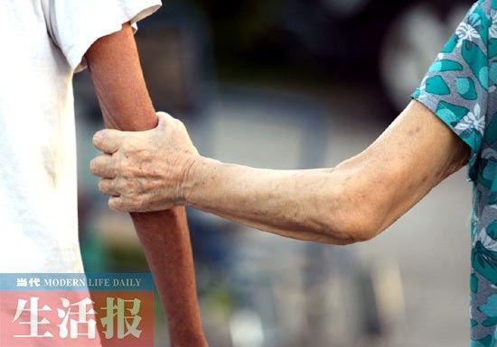 7月17日，南宁市一家养老院内，两名老人牵手散步。 记者 何学俏 摄