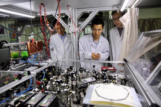 5月3日,中国科学技术大学陆朝阳教授(中)和学生们在中科院量子信息和量子科技创新研究院上海实验室检查光量子计算机的运行情况。新华社记者 金立旺 摄