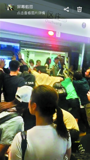 地铁工作人员和众多男乘客合力推地铁车厢。 （图片来自网友朋友圈截图，请作者与本报联系。）