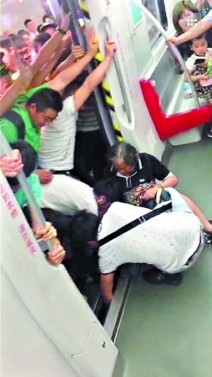 一名乘客在车厢里帮助女乘客把右腿拔出来。（图片来自网友朋友圈截图，请作者与本报联系。）