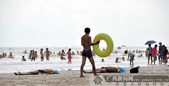 　　两名溺水者的尸体搁在沙滩上，其他冲浪者浑然不觉。记者 许海鸥摄