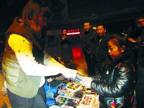 夜晚的灯光下，垚垚仍在不知疲倦地叫卖袜子。