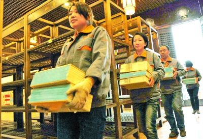 工作人员在扬州天宁寺万佛楼内搬运《四库全书》。新华社发（庄文斌摄）