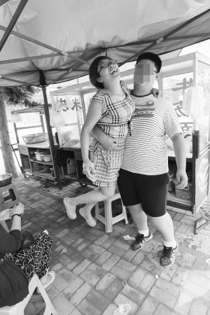 亮亮一只胳膊就能将妈妈抱起。