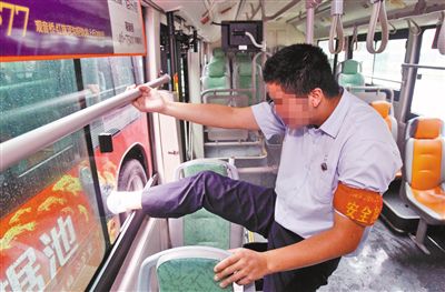 公交车司机唐师傅模仿扒手当时想跳窗逃走的样子。