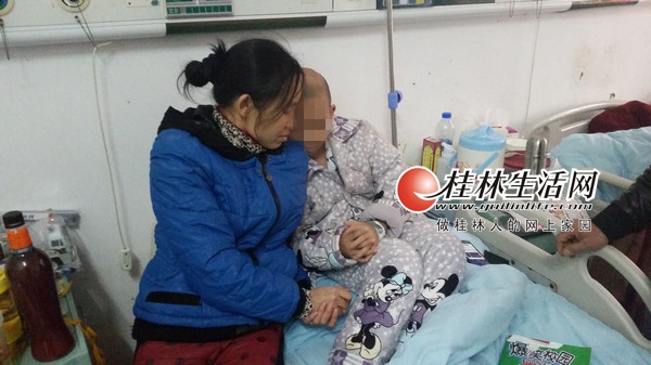 病床上,嘉嘉和母亲手牵手。