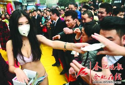 昨天下午,步行街东一度被市民堵得水泄不通。原来,这里有几名身穿比基尼的女模特正在给市民免费发放防雾霾口罩。