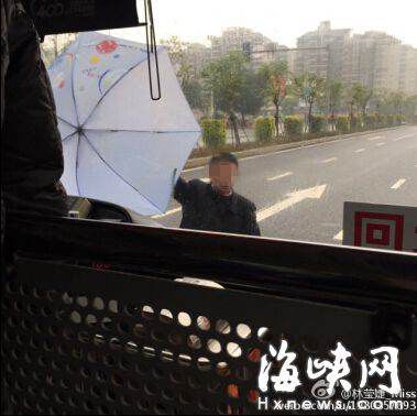男子要上公交车遭拒,用伞拦在车前。网友供图。