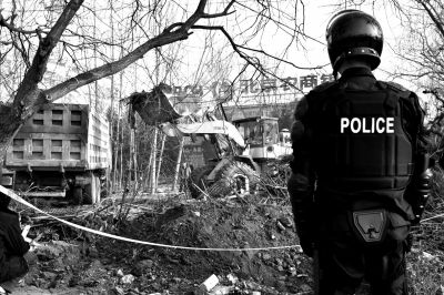 挖掘机将地面杂物清理,用车运走。京华时报记者周民摄