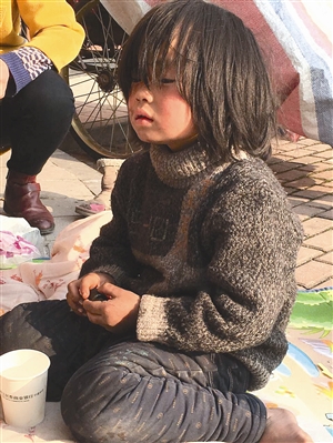 接受爱心救助前,小女孩光着脚丫,衣衫褴褛。