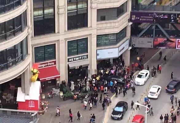 女子误踩油门致车失控 路人被夹车头与墙体之间