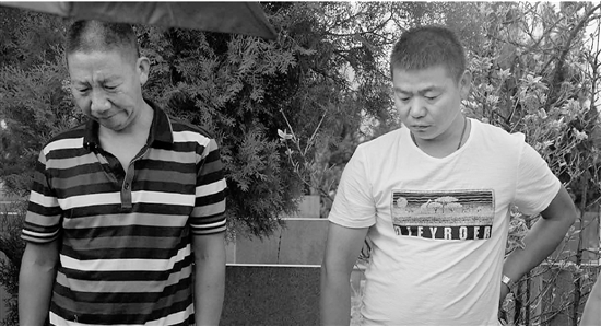 李荣福（左）和马建华（右）兄弟俩在母亲墓前泪流满面。
