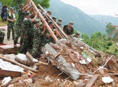 官兵在福建南安九都镇林坑村搜救遇难者。
