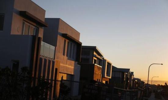 资料图片：夕阳映照着正在修建中的悉尼百万美元住宅区。