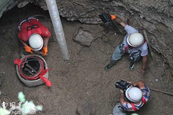 井下人员将寻找到的骸骨装入骨灰坛中。