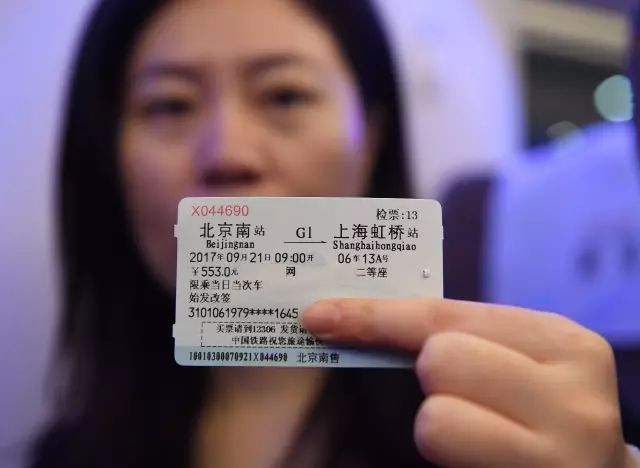 2017年9月21日，一名乘客在G1次“复兴号”列车内展示车票。新华社记者李贺摄