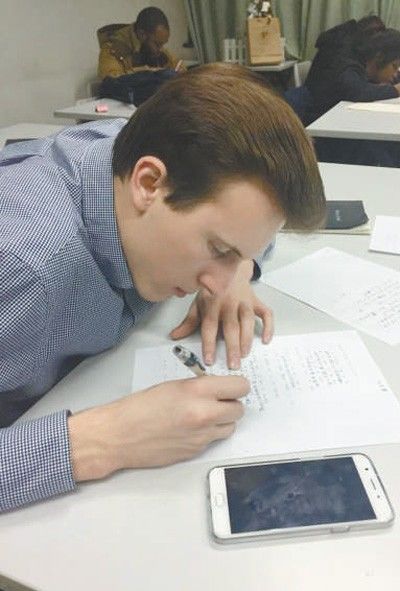▲外国学生马修·塞申斯在课堂上认真地用中文完成老师布置的作业。