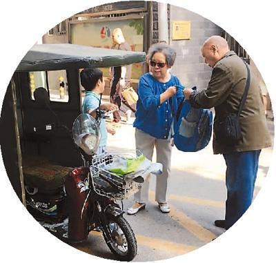 　5月10日，北京市朝阳区某小学放学后，2名随迁老人骑着三轮车接孩子。本报记者 彭训文摄