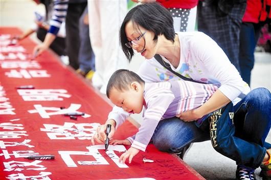 图为：“妈妈，我也要签名”