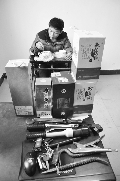 嫌犯在堆满赃物的桌前吃着民警送来的盒饭。记者万勤 摄