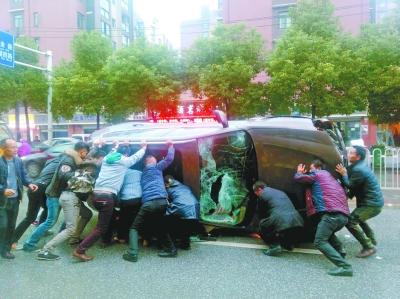 宝马为避公交骑上护栏侧翻 市民合力扶车救人