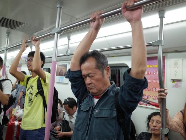 爹爹扶杠睡觉让人心疼 市民建议地铁设爱心专座 爹爹扶杠睡觉让人心疼 市民建议地铁设爱心专座