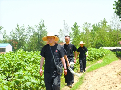 去年夏天李志强(左一)在蔡甸区消泗乡巡堤(资料照片)