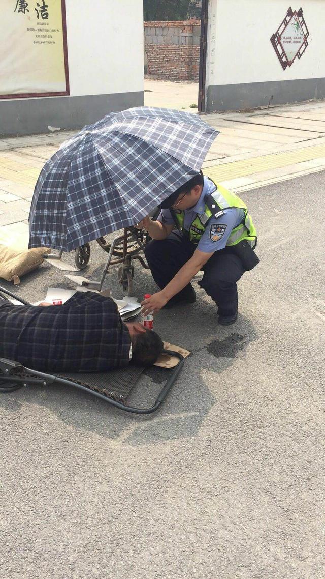 老爹爹平躺街头不能动弹，民警蹲着为其撑伞20分钟