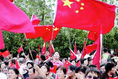 图为:武汉百步亭社区居民摇动鲜艳的五星红旗,喜迎国庆.