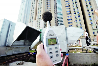 21日,城管执法人员在现场使用分贝记录仪测量噪声 记者刘斌 摄