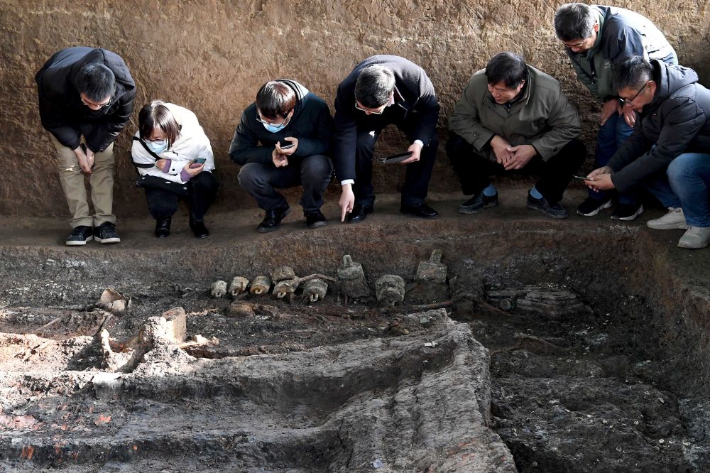 考古专家和学者在查看标号为m15的墓葬发掘现场