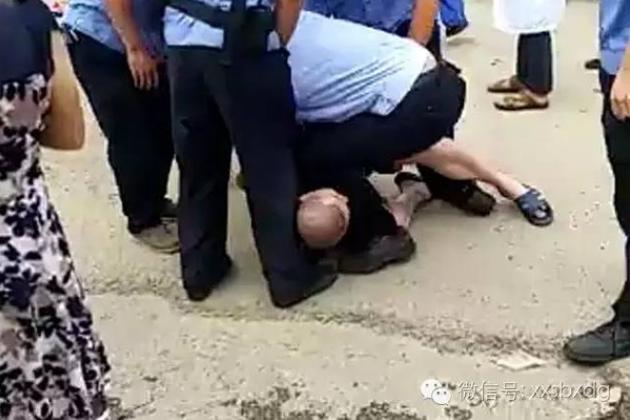 目击者所拍摄的李刚被压在地上的视频截图。